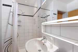 a white bathroom with a sink and a mirror at Hegaudomizil in Engen +20 photos