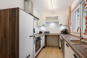 a kitchen with white cabinets and a sink at Hegaudomizil in Engen