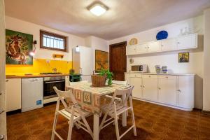 a kitchen with a table and chairs in a room at Casa al mare con ampia veranda in Stintino +21 photos