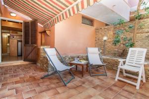 two chairs and a table on a patio at Casa al mare con ampia veranda in Stintino