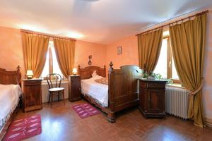 a bedroom with a bed with wooden furniture and windows at Les Pruniers - Orbey in Orbey
