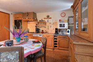 a kitchen with a table with a pink table cloth at Les Pruniers - Orbey in Orbey