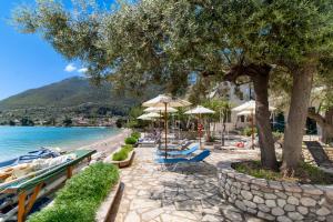 a beach with chairs and umbrellas and the water at M2 room in Nikiana