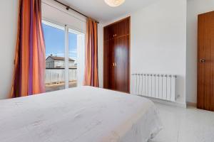 a bedroom with a bed and a large window at Creixell in Creixell
