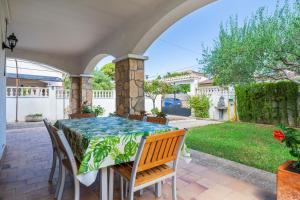 a patio with a table and chairs and a yard at Creixell in Creixell