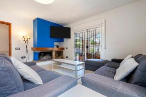 a living room with two blue couches and a fireplace at Creixell in Creixell