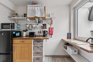 a small kitchen with a counter and a refrigerator at Ferienhaus Nilsson in Heide +19 photos