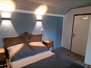 a bedroom with a bed with two lights on the wall at Zimmer in Müsch nahe Nürburgring in Müsch