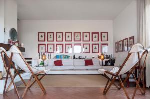 a living room with a white couch and two chairs at Il Grifo - Cozy house, wonderful view in Portoferraio