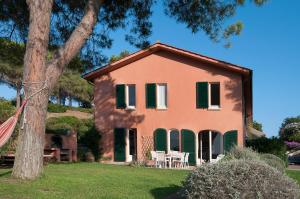 an orange house with green shutters and a tree at Il Grifo - Cozy house, wonderful view in Portoferraio
