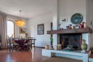 a living room with a fireplace and a dining room at Il Grifo - Cozy house, wonderful view in Portoferraio +24 photos