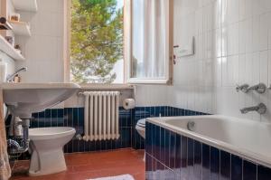 a bathroom with a sink and a tub and a toilet at Il Grifo - Cozy house, wonderful view in Portoferraio