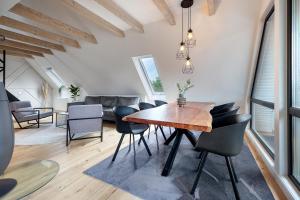 a dining room with a wooden table and chairs at Penthouse Kokorey in Halstenbek