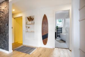 a surfboard hanging on a wall in a bathroom at Penthouse Kokorey in Halstenbek +22 photos