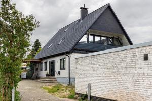 a white brick house with a black roof at Penthouse Kokorey in Halstenbek