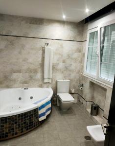 a bathroom with a bath tub and a toilet at Casa Pablo Picasso 9 in Jimena de la Frontera +15 photos