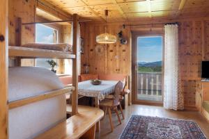a bedroom with bunk beds and a table and a balcony at Apartment Rosengartenblick in Steinegg