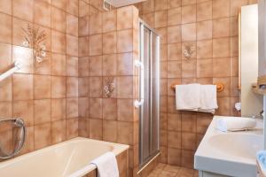 a bathroom with a tub and a sink at Apartment Rosengartenblick in Steinegg +24 photos