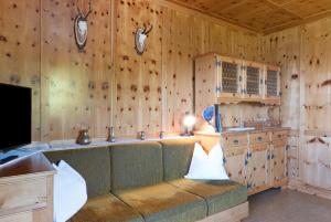 a living room with a couch in a room with wooden walls at Apartment Rosengartenblick in Steinegg