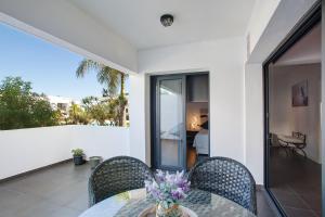 a table with chairs and a vase of flowers on a balcony at The Garden Secret in Villaverde