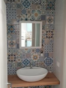 a bathroom with a sink and a mirror and tiles at Il Rosmarino in Marciana
