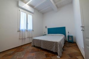 a white room with a bed and a window at Il Rosmarino in Marciana