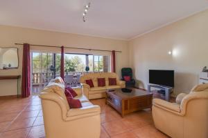 a living room with two couches and a tv at Villa do Lago in Albufeira