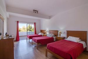 a hotel room with two beds and a window at Villa do Lago in Albufeira +21 photos