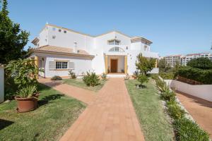 a white house with a brick walkway at Villa do Lago in Albufeira