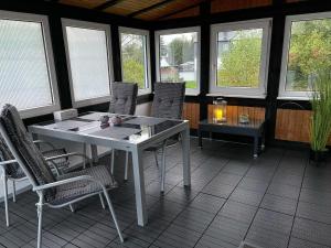 a white table and chairs in a room with windows at Ferienwohnung Blum in Schmallenberg