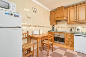 a kitchen with wooden cabinets and a wooden table at Apartmento Los Alamos in Nerja +15 photos