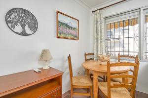 a dining room with a wooden table and chairs at Apartmento Los Alamos in Nerja