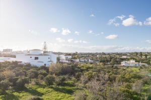 a view of a white building on a hill with trees at Casa Guerreiro in Branqueira