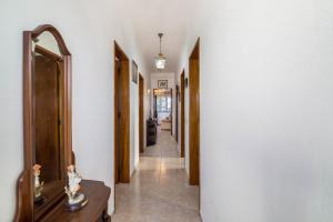 a hallway with white walls and a mirror and a table at Casa Guerreiro in Branqueira +17 photos