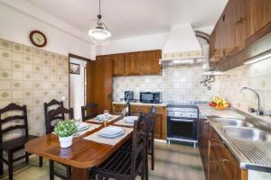 a kitchen with a wooden table and a dining room at Casa Guerreiro in Branqueira