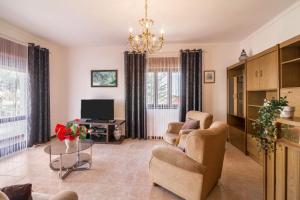 a living room with two chairs and a tv at Casa Guerreiro in Branqueira