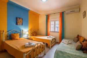 a small room with two beds and a couch at T2 Anastácio com vista Jardim in Olhos de Água +18 photos