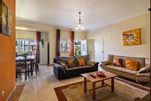 a living room with a couch and a table at T2 Anastácio com vista Jardim in Olhos de Água