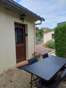 a table and chairs in front of a house at Gite paysan lecarpentier in Fontenay