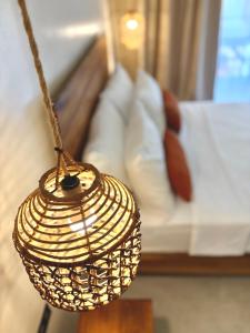 a rattan lamp in a room with a bed at Laya Boutique Hotel in General Luna