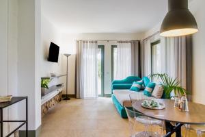 a living room with a blue couch and a table at Casale Lorenzo Appartamenti in Orbetello