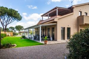 a house with a green lawn in front of it at Casale Lorenzo Appartamenti in Orbetello
