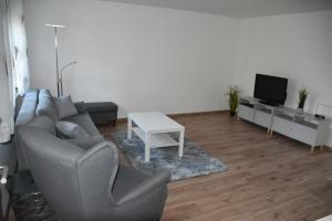 a living room with a couch and a table and a tv at Casa Schrader in Kaltenholzhausen