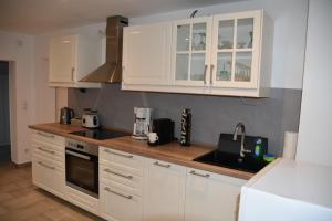 a kitchen with white cabinets and a sink at Casa Schrader in Kaltenholzhausen