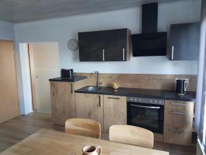 eine Küche mit Holzschränken, Spüle und Herd in der Unterkunft Ruth in Dahn