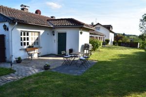 a white house with a table and chairs in the yard at Casa Schrader in Kaltenholzhausen