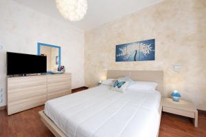 a bedroom with a large white bed and a flat screen tv at Il ponte dei sogni in Brescia +22 photos