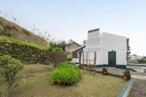 a small white house with a stone wall at A Casa d'Amália in Ginetes