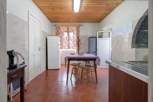 a kitchen with a table and a refrigerator at A Casa d'Amália in Ginetes