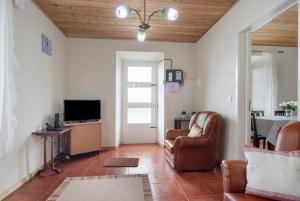 a living room with a couch and a television at A Casa d'Amália in Ginetes